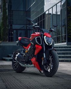 a red and black motorcycle parked in front of a building with the words tap here to see more