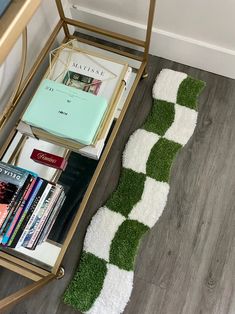 a green and white rug sitting on top of a wooden floor next to a chair