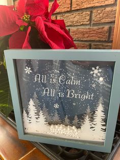 a sign that says all is calm, all is bright with snowflakes and poinsettis