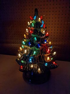 a lit up christmas tree sitting on top of a table