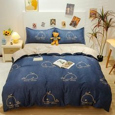 a bed with blue comforter and pillows on top of it next to a plant