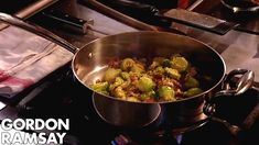 a pan filled with food sitting on top of a stove next to a frying pan