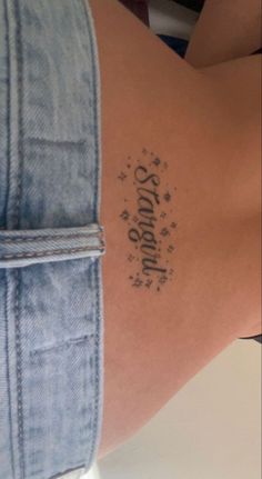 the back of a woman's stomach with stars and words tattooed on her side