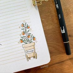 a notepad with an orange tree on it next to a pen and a pencil