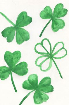 four leaf clovers painted in green on white paper