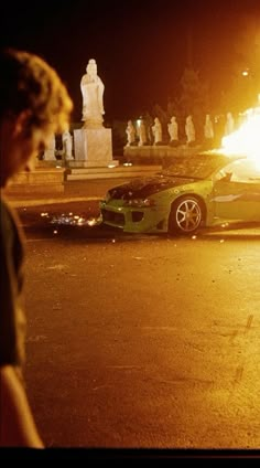 a car that is sitting in the street next to a fire hydrant and people