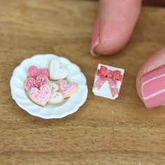 a close up of a person's hand next to a plate with cookies on it