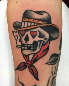 a skull with a hat and bow tie on it's leg is wearing a red ribbon