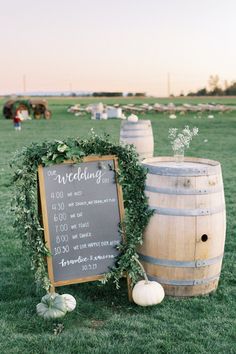 a wooden barrel with greenery on it and a chalkboard sign next to it