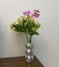 a vase filled with flowers on top of a wooden table