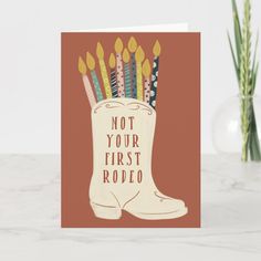 a card with candles sticking out of a boot that says not your first rodeo on it