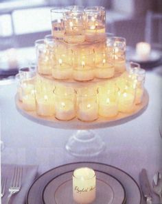 candles are arranged on top of a glass cake platter for an elegant wedding reception