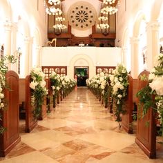 the interior of a church decorated with flowers and greenery