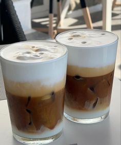 two glasses filled with liquid sitting on top of a table