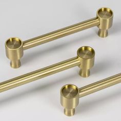 three brass colored metal handles and knobs