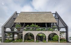 an old building with plants growing on the roof