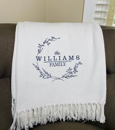 a white blanket with the words, williams family printed on it sitting on a couch