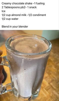 a person holding a glass cup filled with liquid