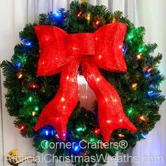 a christmas wreath with lights and a red bow