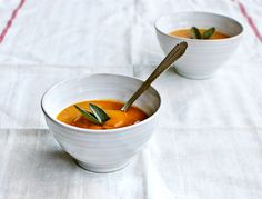 two white bowls filled with soup on top of a table