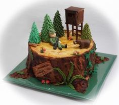 a cake that is shaped like a tree stump with a man sitting on top of it