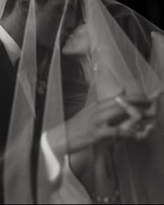 a bride and groom are kissing under the veil