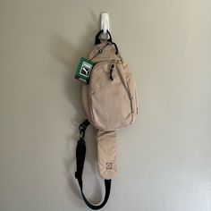 a backpack hanging on the wall with a leash attached to it's back pocket