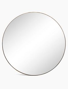 a round mirror sitting on top of a white wall