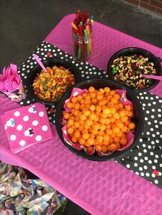 a table topped with lots of food on top of a pink table cloth covered in polka dots