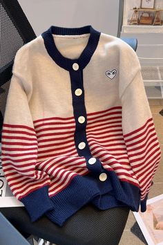 a red, white and blue sweater sitting on top of a chair