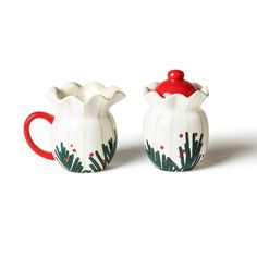 two white and red ceramic pitchers sitting next to each other