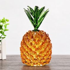 a glass pineapple sitting on top of a wooden table