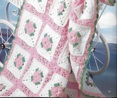 a pink and white crocheted blanket sitting on top of a bike