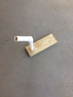 a white object is on the ground near a piece of wood and a plastic pipe