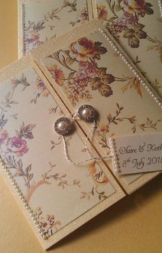 two wedding cards with flowers and pearls on them