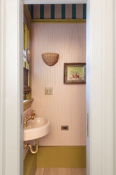 an open door leading to a bathroom with pink walls and green striped carpeting on the floor