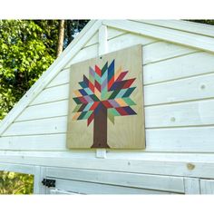 a wooden sign with a colorful tree on it