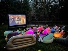 an outdoor movie is set up with inflatable chairs