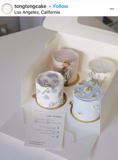 there are two cakes in the box on the table and one is decorated with flowers