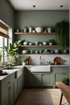 a kitchen filled with lots of green cupboards and white counter tops next to a window