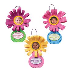 three different colored flower shaped ornament with a child's photo in the center