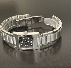 Gucci beautiful women's  6 1/2" silver - black square link timepiece, Swiss made and pre-owned with a new battery, gives precise time, with a wonderful new crystal, and recently serviced by a professional jeweler. Serial number 003683 embossed @ back base and 100% authentic guaranteed. with a protective seal @ back base.  Model 7700L and a 27mm case (the dial is the size of a quarter) Please view my 100% positive reviews it tells my history. with same day secure, fast shipping, Thank you for your consideration. Silver Rectangular Watch Accessories With Diamond Hour Markers, Timeless Silver Square Watch, Rectangular Silver Metal Watch, Silver Rectangular Metal Watch, Elegant Rectangular Watch With Stainless Steel Clasp, Elegant Silver Square Watch, Silver Rectangular Watch Dial With Diamond Hour Markers, Silver Rectangular Analog Watch, Silver Square Watch With Metal Dial