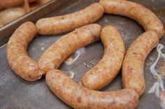 two long sausages are on a tray ready to be cooked and put in the oven