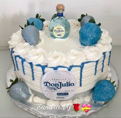 a white cake with blue icing and strawberries on top