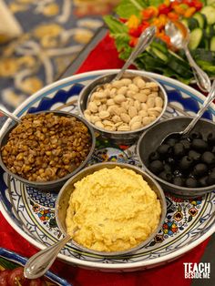 an assortment of food on a plate with spoons and utensils next to it