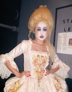 a mannequin dressed as a woman in a white dress with yellow hair and makeup