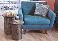 a living room with a blue chair and side table in front of a fire place