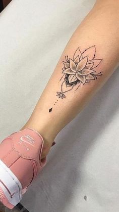 a woman's arm with a flower tattoo on the left side of her forearm