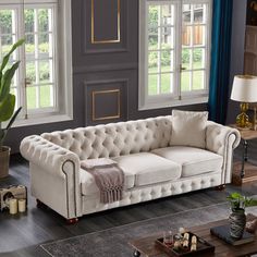 a living room filled with furniture next to two windows and a rug on the floor