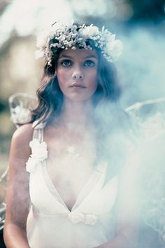 a woman in a white dress with flowers on her head